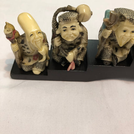 Seven Oriental Figurines On A Stand.