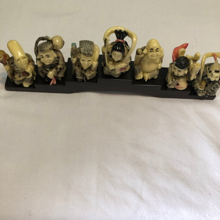 Seven Oriental Figurines On A Stand.