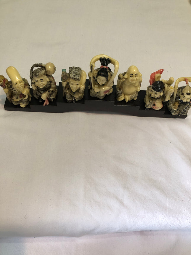 Seven Oriental Figurines On A Stand.